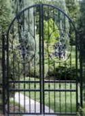 Ornate wrought iron garden gate with arched top.