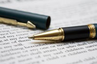 Image of pen on a contract. This shows the business has won its first contract!