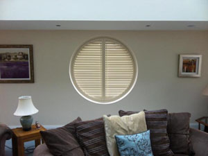 Round window fitted with venetian blinds by Bespoke Blinds & Poles of Sheffield.